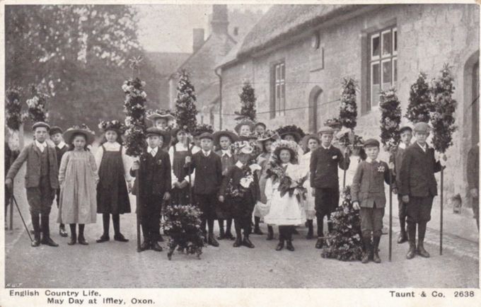 Children at Iffley bearing garlands outside the thatched village school on May Day 1906 - a Henry Taunt photograph reproduced as a postcard.