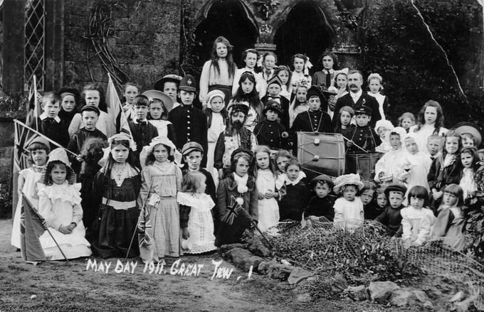 May Day pageantry at Great Tew, 1911. The children pose outside the parish church which now gives its blessing to the revels.