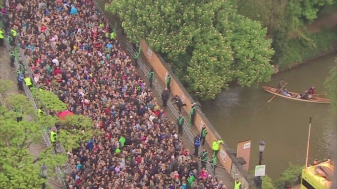 Stewards in fluoro jackets keep the crowds back from the walls of the bridge to prevent people from jumping into the river. Photo ITV Meridian